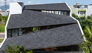 tent house expands under overlapping roof planes in vietnam