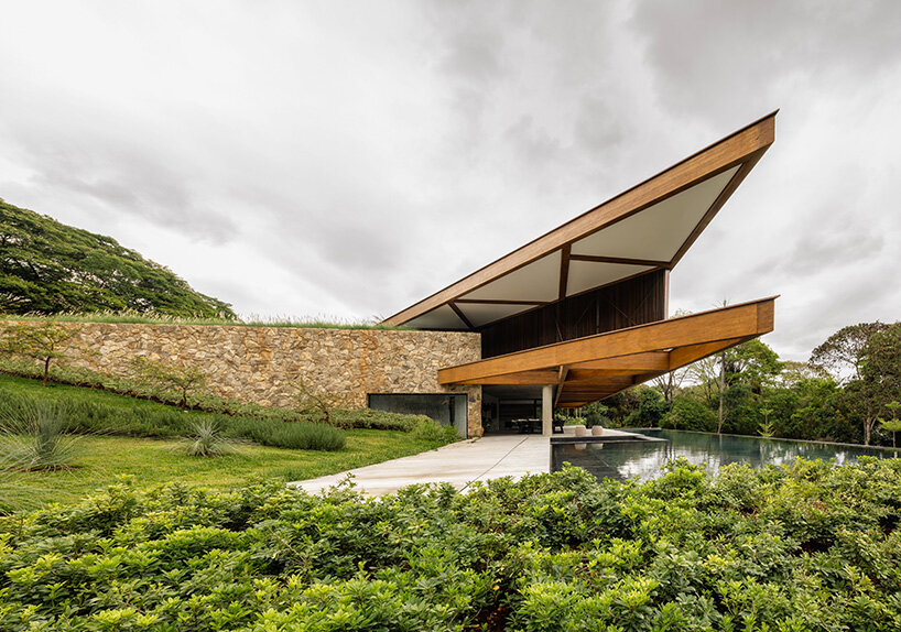 TETRO's lakeside residence in brazil vanishes into the horizon beneath triangular timber roof