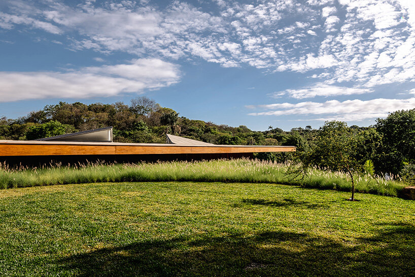 TETRO's lakeside residence in brazil vanishes into the horizon beneath triangular timber roof