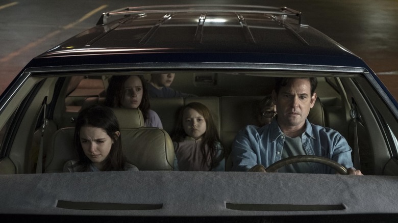 The Crain family sat in a car scared on The Haunting of Hill House