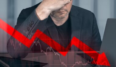 A person with their head in their hands and a down arrow on an overlay of a stock graph.