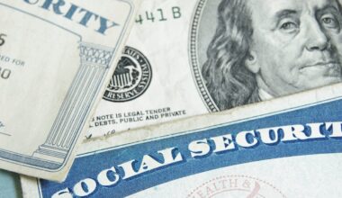 Two Social Security cards lie atop U.S. currency.