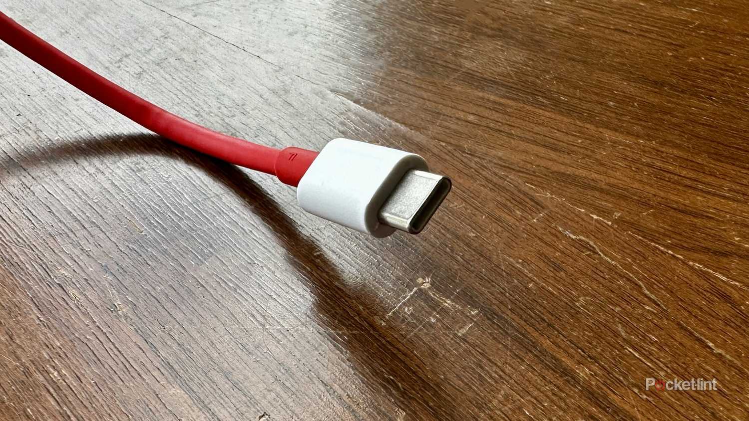 A red USB-C cable on an old cedar chest.