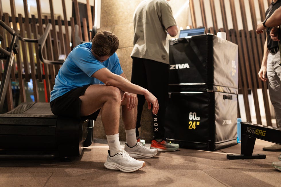 Man sitting on treadmill after completing a VO2 max test man resting after a workout in a gym setting