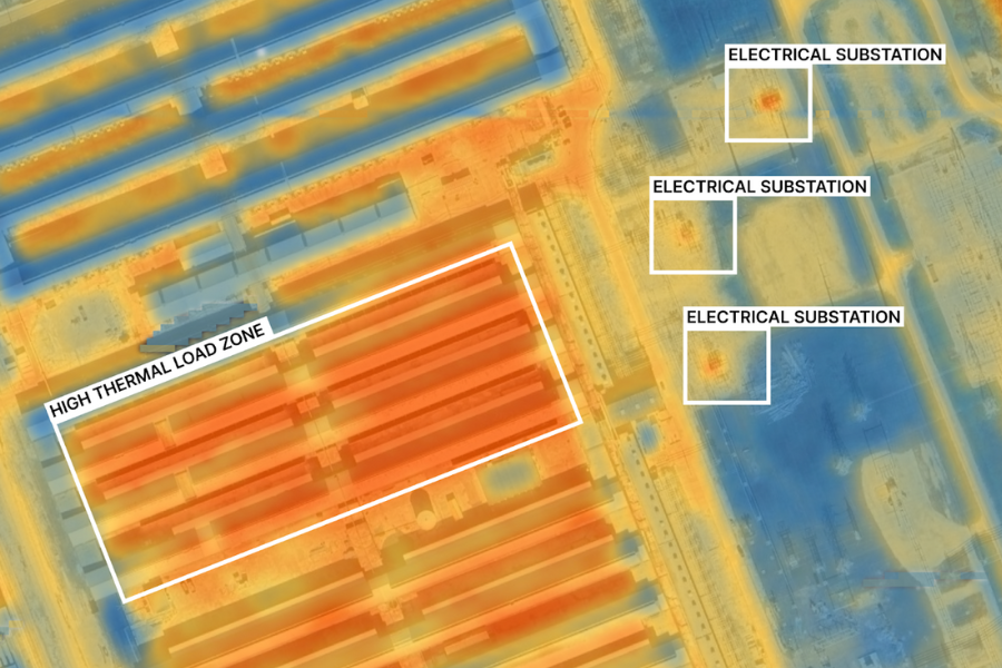 An orange, yellow, and blue heat image showing rows of orange heated architecture in the middle of an urbanized area. White boxes show labeled sections including electrical substations and high thermal load zones