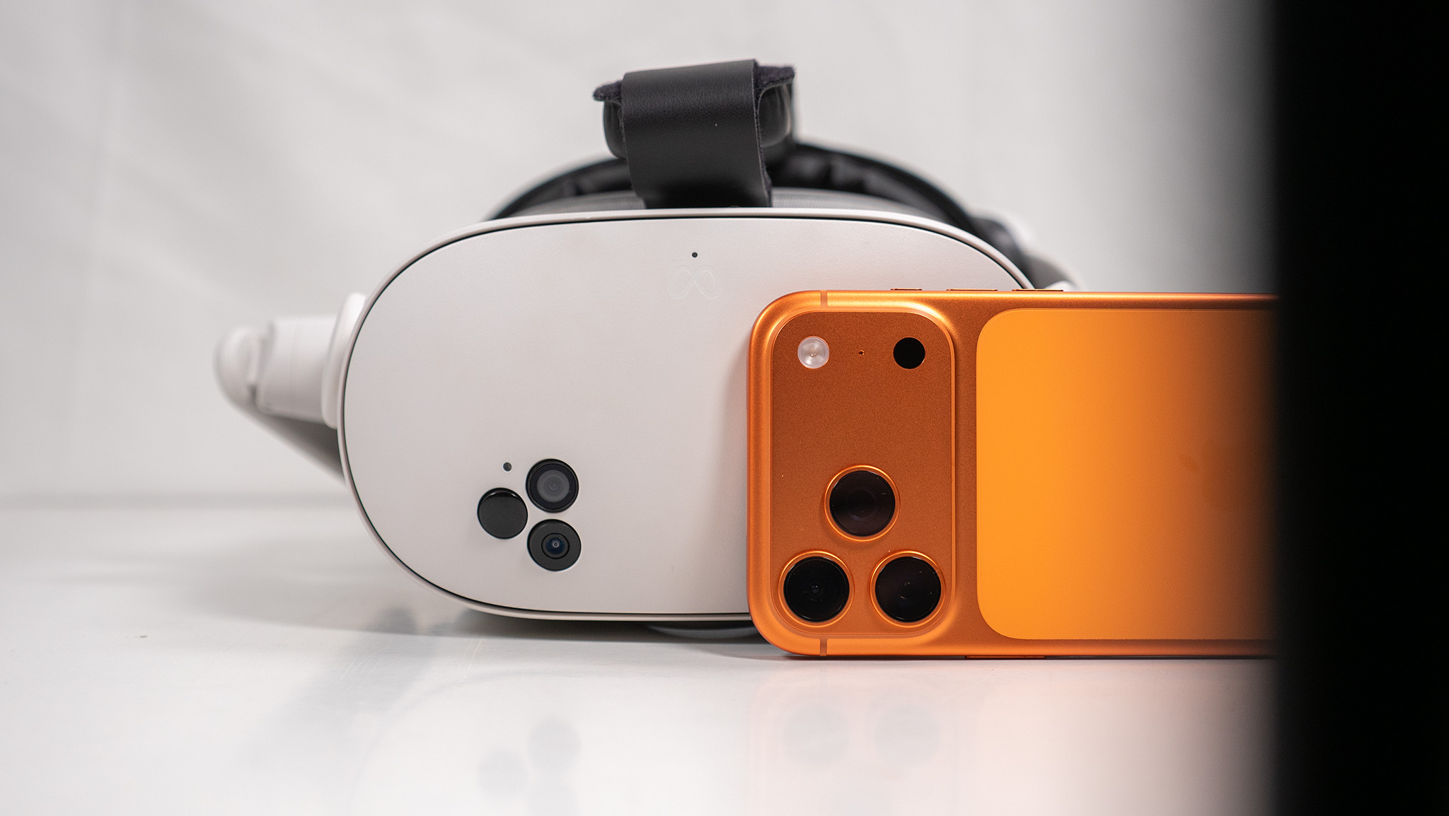 A Meta Quest 3S headset behind an orange iPhone 17 Pro Max
