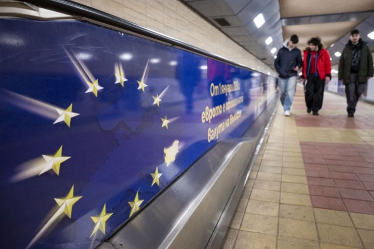 Commuters walk past an advertisement promoting Bulgaria's entry into the Eurozone in Sofia's subway on December 31, 2025, ahead of the country's adoption of the euro on January 1, 2026. (Photo by Nikolay DOYCHINOV / AFP)