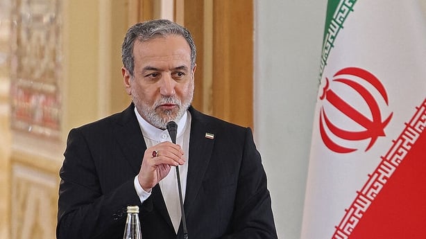 Iranian Foreign Minister Abbas Araghchi speaking in front of an Iranian flag.
