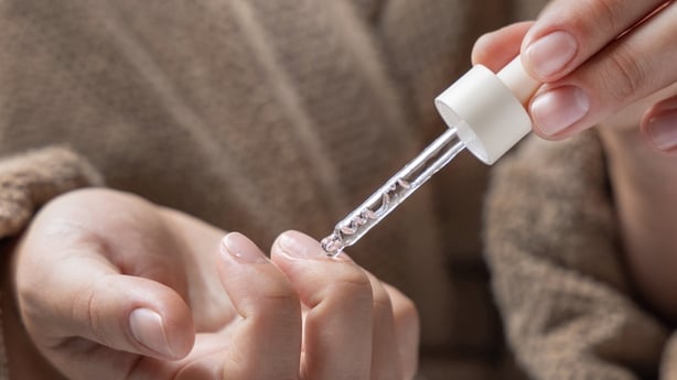 close up of woman applying oil to her nails