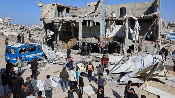 Rescuers and onlookers inspect the debris of Sheikh Radwan police station in Gaza City