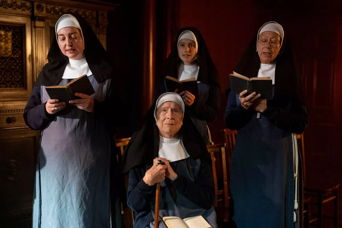 Call the Midwife's Sister Julienne holding a book and walking stick