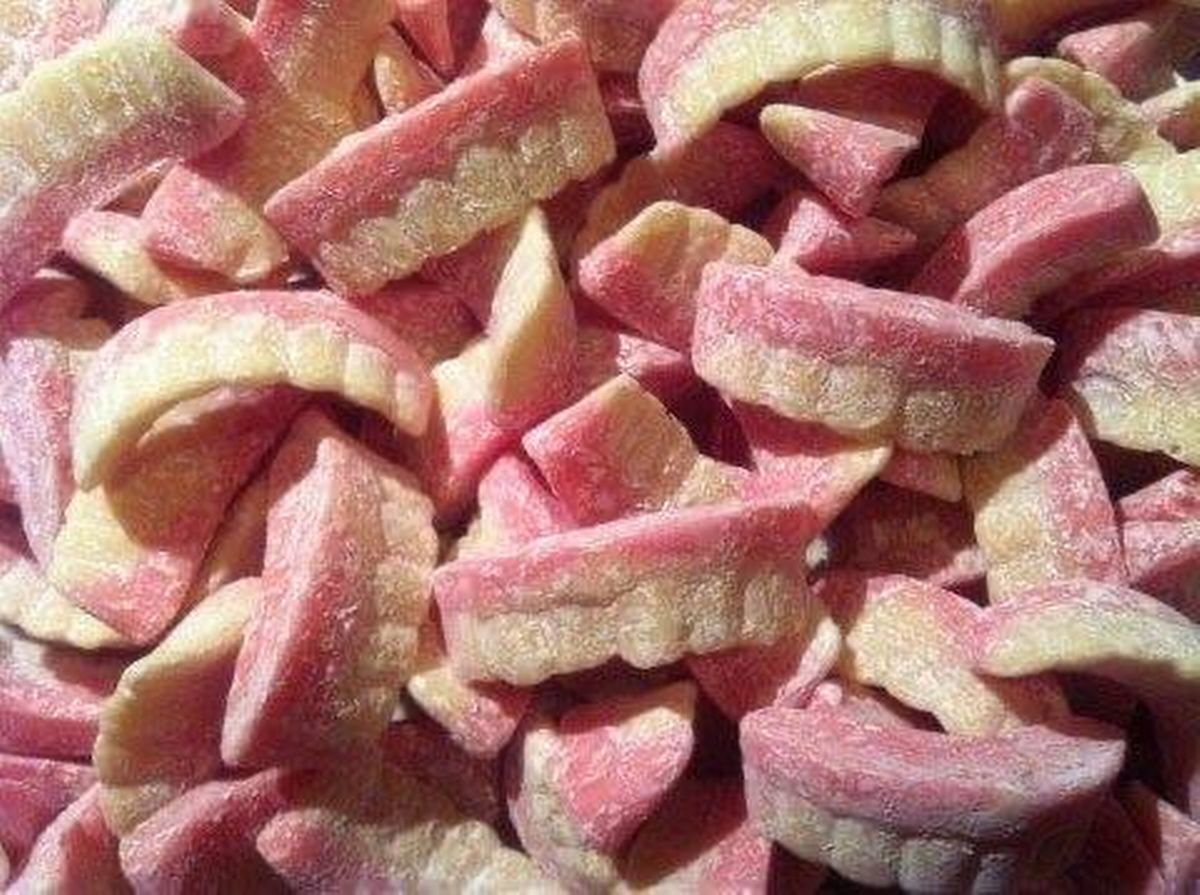 A colour photo of pink and white milky teeth penny sweets