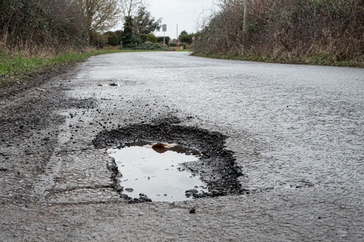 Deep road pothole filled with rainwater