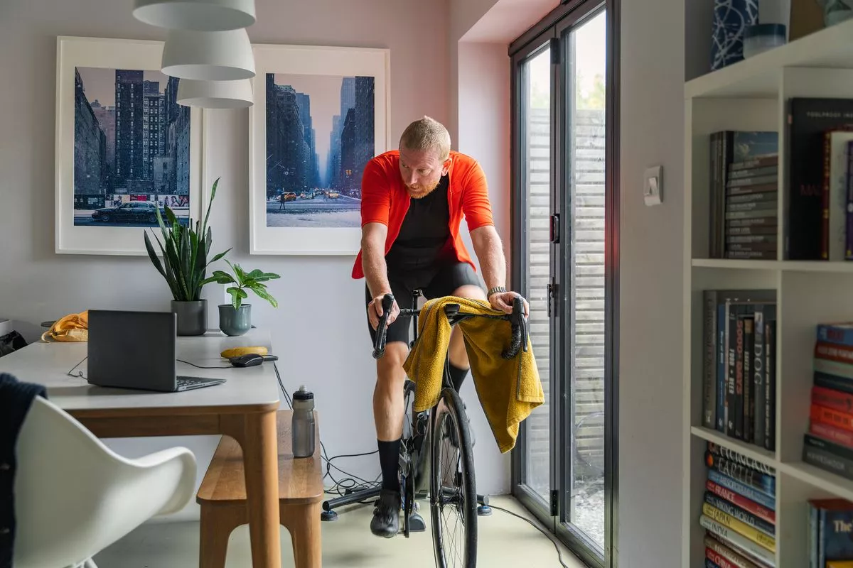 Shot of a mature man using his indoor cycling turbo trainer at home - stock photo