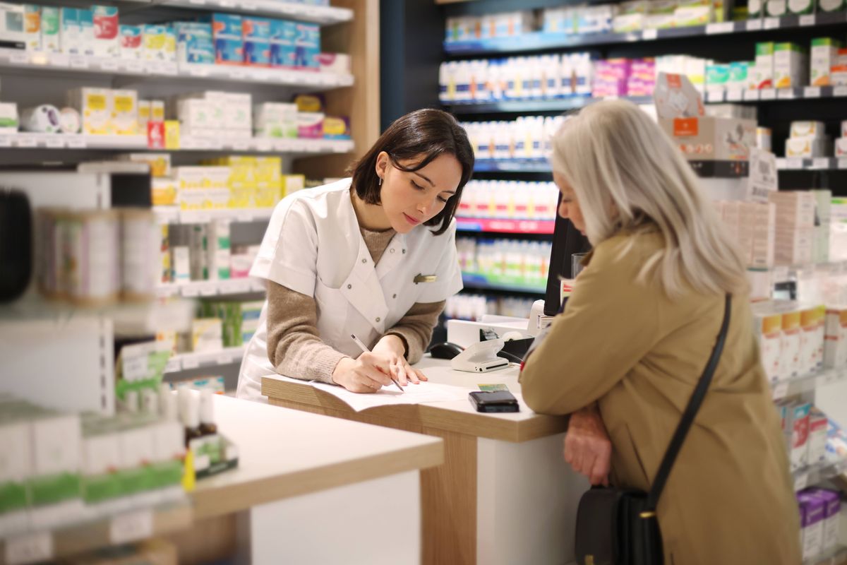 Pharmacist giving recommendations to a senior customer at a pharmacy counter