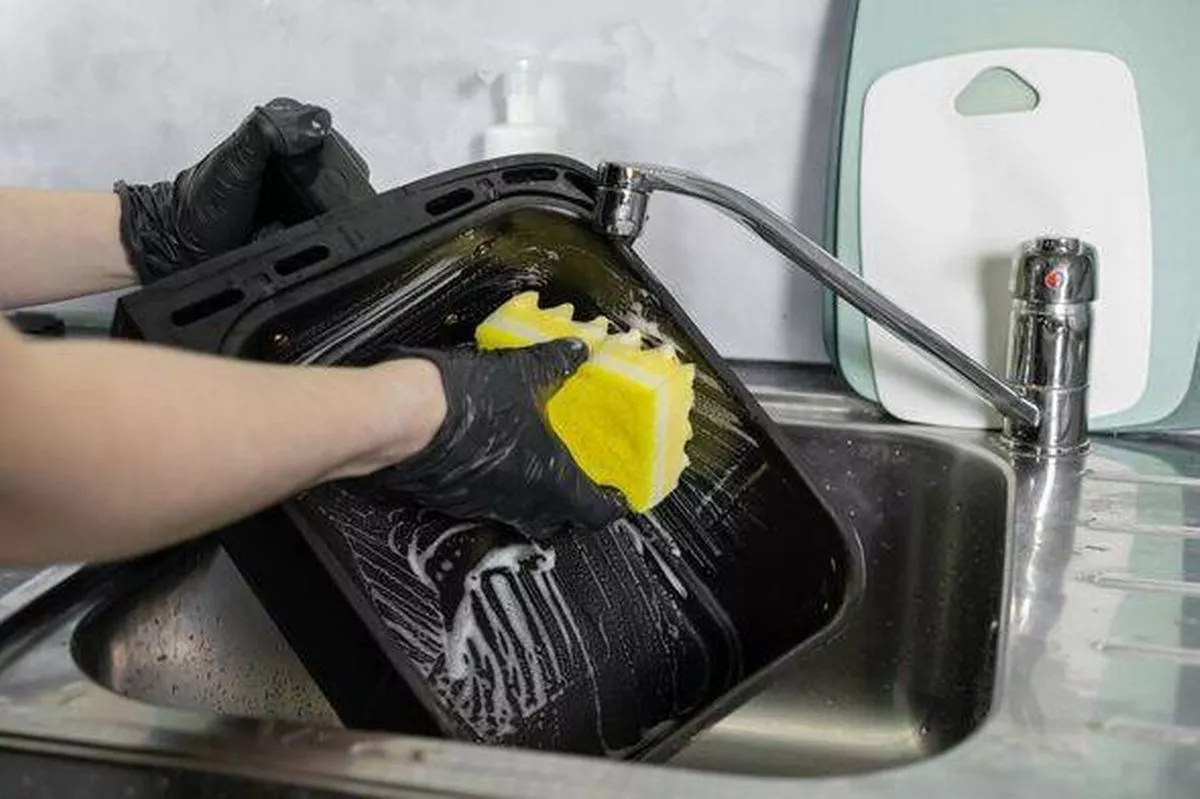 Hands washing air fryer