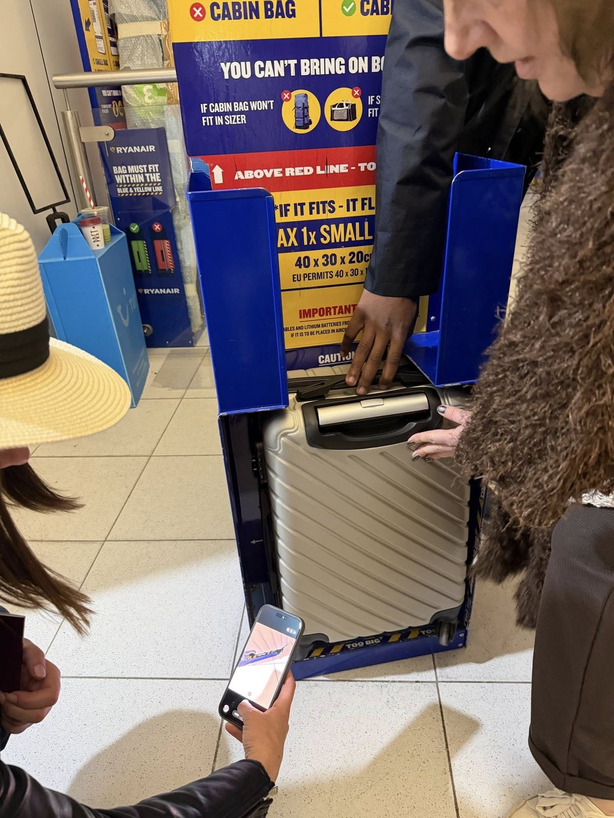 Pictured: Gilly shows the bag of another woman who she claims was fined too, despite her bag appearing to fit in the sizer.