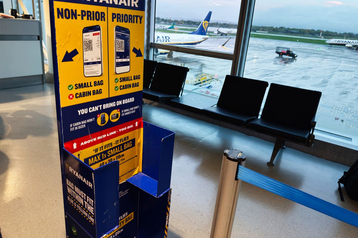 Manchester, UK - October 04, 2025: Bright Ryanair signage guides passengers in a Manchester airport setting with planes visible outside.