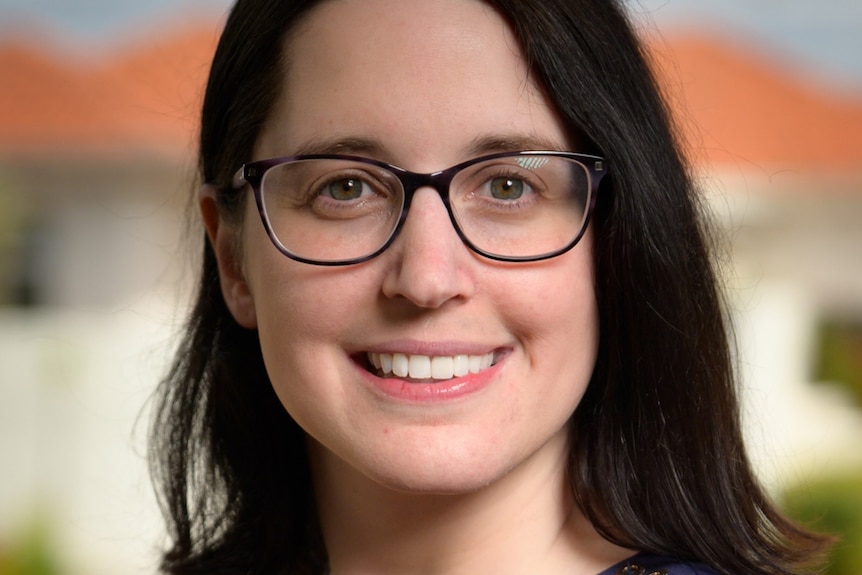 A close-up shot of a woman wearing glasses.