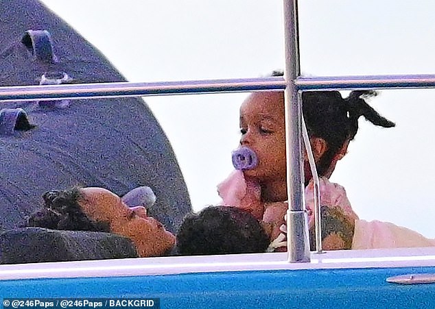 While cruising across the North Atlantic Ocean, the Diamonds hitmaker was seen lovingly tending to her little ones and laying down with little Riot across her chest