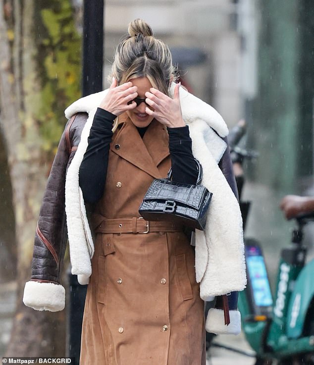 Ashley quickly shielded her face from the rain