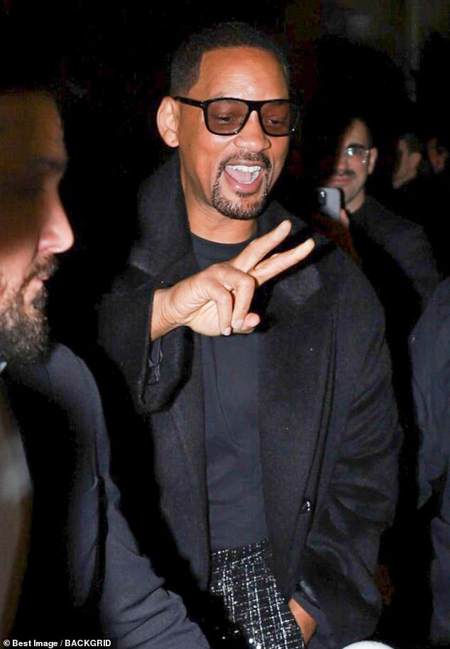 The pair paused for a brief photo session outside of the runway show, with Smith donning a pair of black tweed trousers as well as a plain black shirt