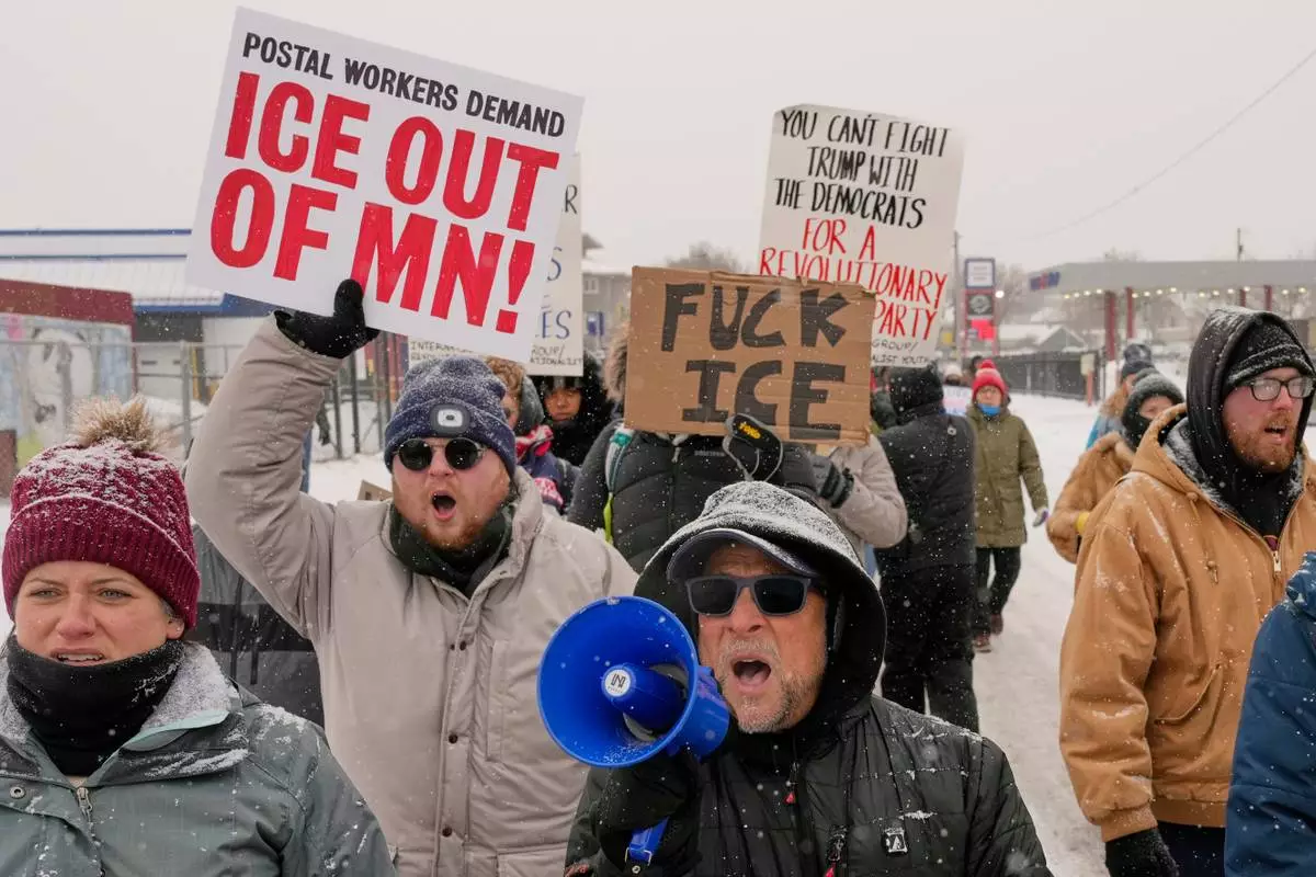 EDS NOTE: OBSCENITY - People march and gather near the post office during a protest, Sunday, Jan. 18, 2026, in Minneapolis. (AP Photo/Yuki Iwamura)