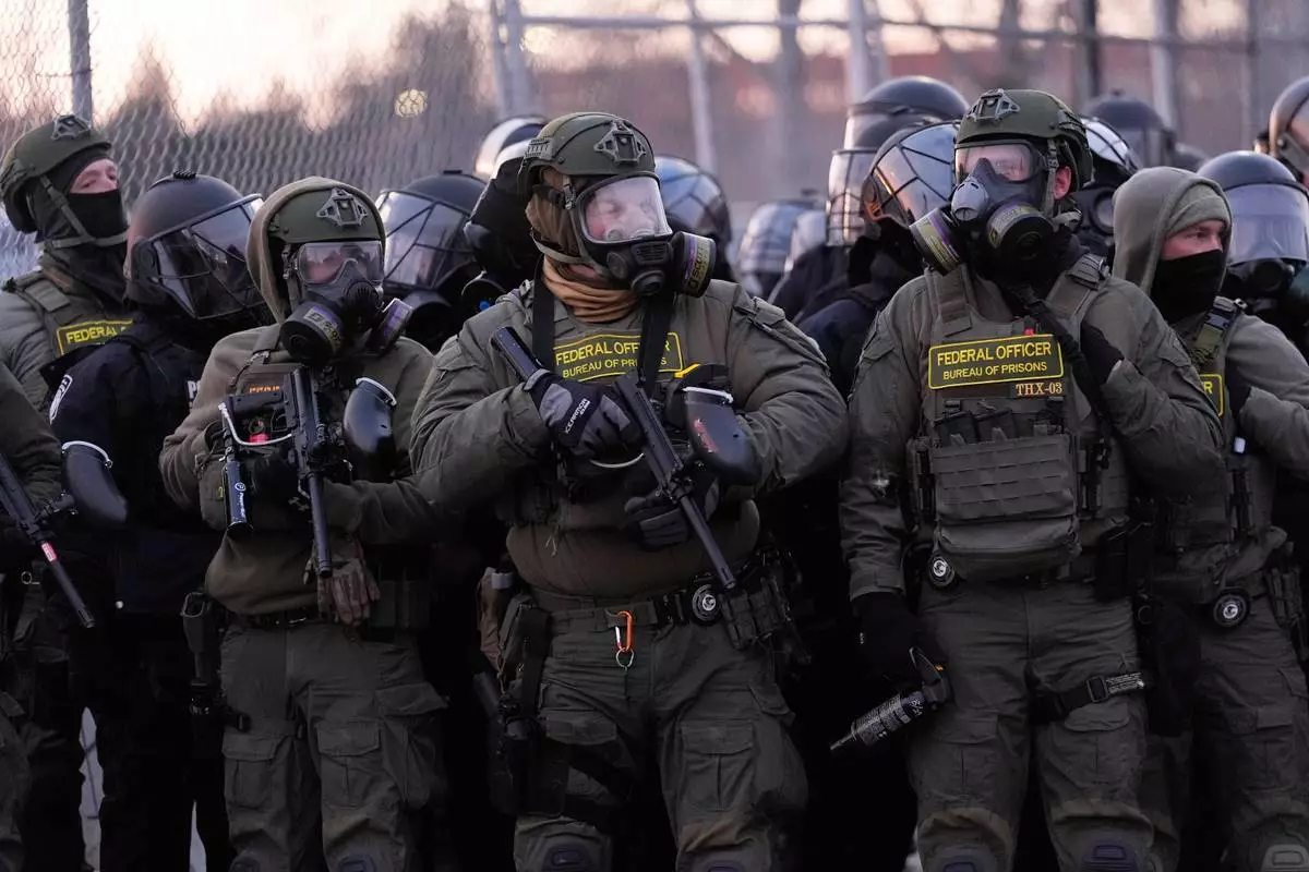 Federal officers stand outside the Bishop Henry Whipple Federal Building during a protest on Saturday, Jan. 17, 2026, in Minneapolis. (AP Photo/Yuki Iwamura)