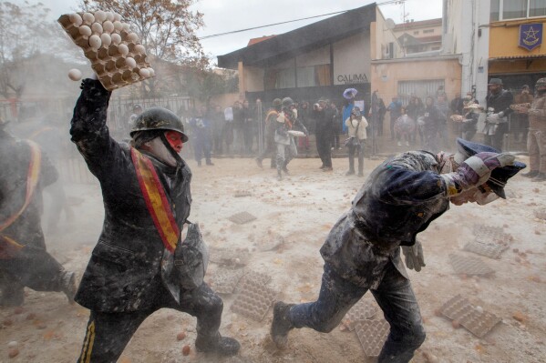 Revelers take part in the Els Enfarinats festival, a battle using flour, eggs and firecrackers, in the town of Ibi near Alicante, Spain, Dec. 28, 2025. (AP Photo/Alberto Saiz File)