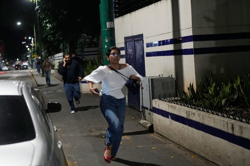 Pedestrians run after explosions and low-flying aircraft were heard in Caracas on Saturday. Photograph: Matias Delacroix/AP