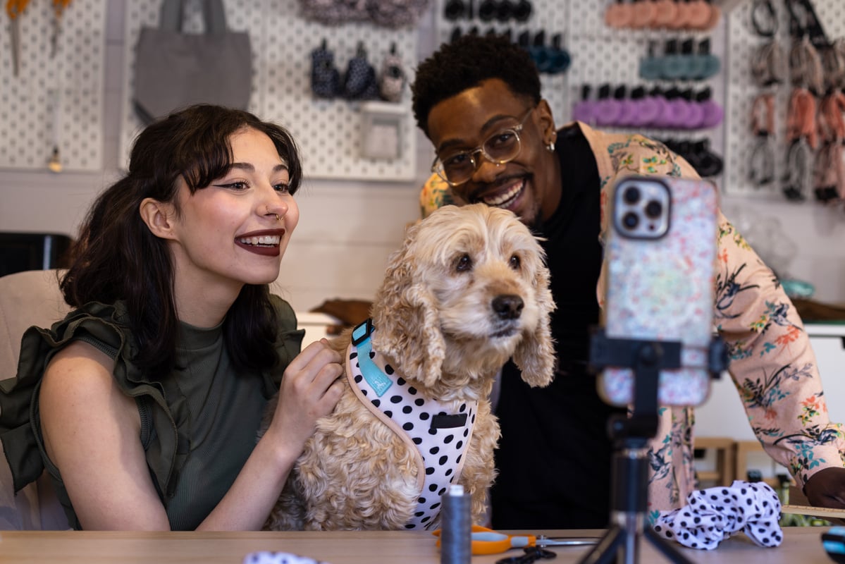 Two people taking a selfie with a dog.