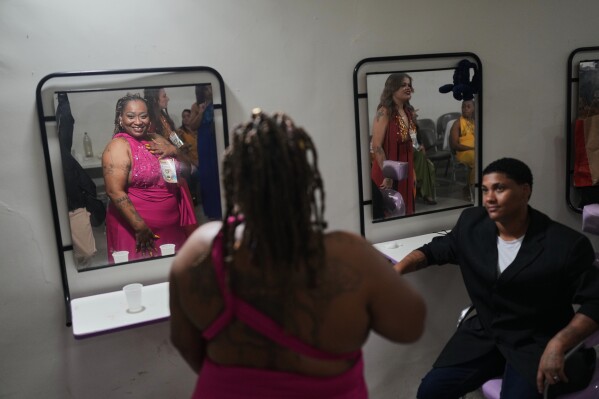Inmates get ready backstage to sing in the Voice of Freedom rehabilitation program event at the Djanira Dolores de Oliveira women's penitentiary in Rio de Janeiro, Friday, Jan. 23, 2026. (AP Photo/Silvia Izquierdo, File)