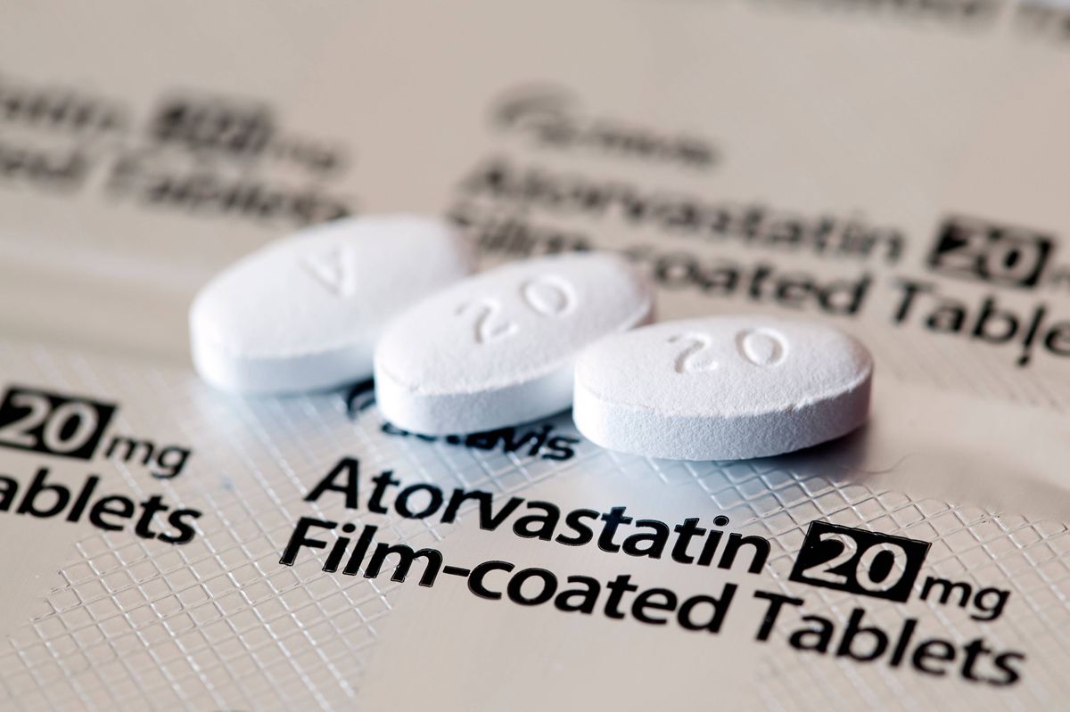 Aberdeen, Scotland - April 7, 2014: Close up view of three Atorvastatin tablets.  Atorvastatin is a member of the drug class known as statins, used for lowering blood cholesterol levels.