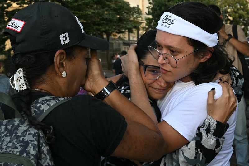 Members of the Committee for the Freedom of Political Prisoners gesture near the entrance to El Helicoide. Photograph: Ronaldo Schemidt/AFP via Getty Images