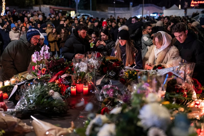 People lay flowers and light candles for the victims of the fire in Switzerland. Photograph: Alessandro della Valle/Keystone via AP
