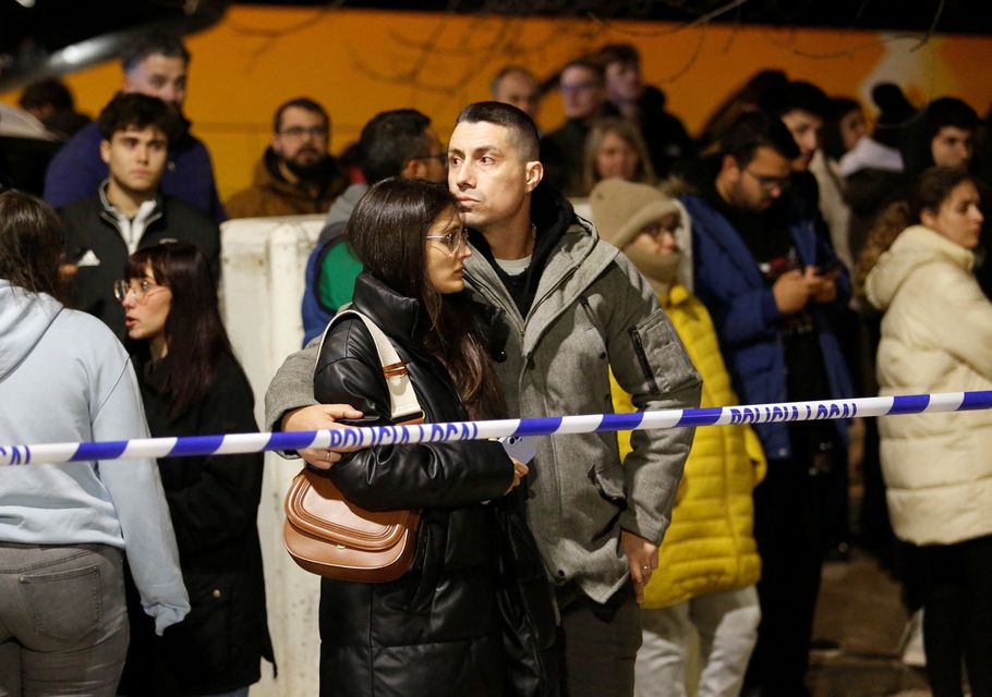 People wait behind the police cordon area, where people affected are transferred and treated at the Caseta Municipal in the town of Adamuz, after a high-speed train derailed and collided with another approaching train near Cordoba, Spain, January 18, 2026. REUTERS/Alex Gallegos