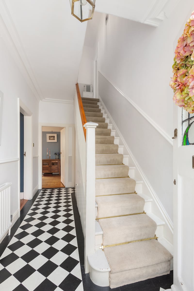 The hallway features a black-and-white tiled floor