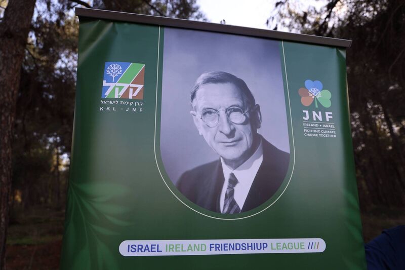 In lieu of the engraved white marble plaque, a colourful printed sign with an austere image of de Valera and a shamrock logo in the blue and green and brown colours of KKL-JNF above the slogan: 'Ireland * Israel | Fighting climate change together.'