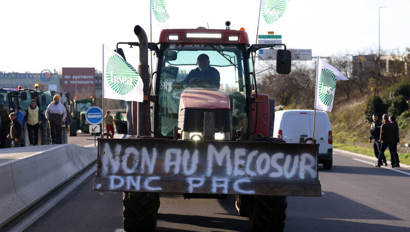 A French farmer drives his tractor to block a main road during a protest against the Mercosur trade deal Dec. 18, 2025 in Portet-sur-Garonne, southwestern France. (AP Photo/Fred Scheiber)