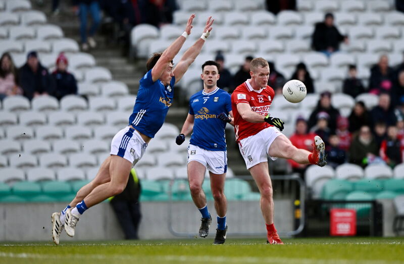 Ruairí Deane of Cork kicks a point despite the attention of Conor Brady of Cavan. Picture: Ben McShane/Sportsfile