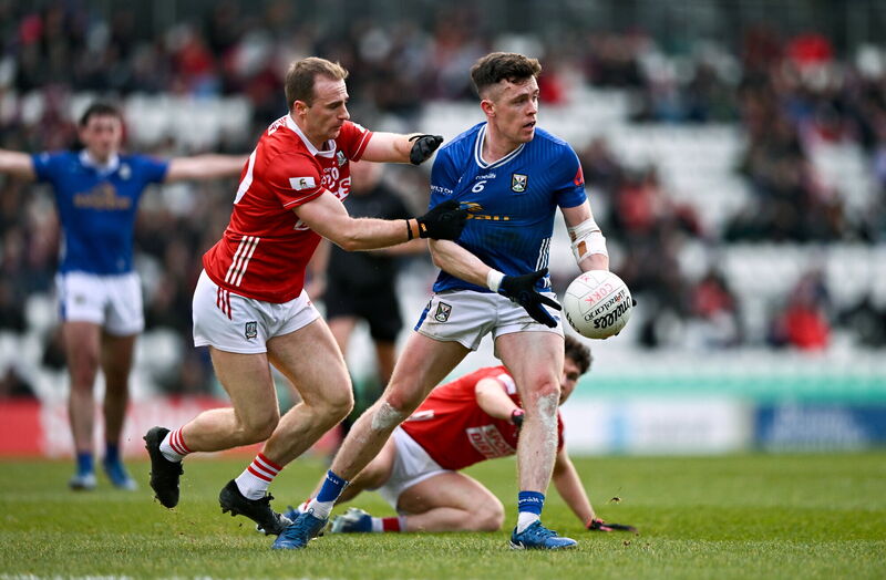 Dara McVeety of Cavan is tackled by Matty Taylor of Cork. Picture: Ben McShane/Sportsfile