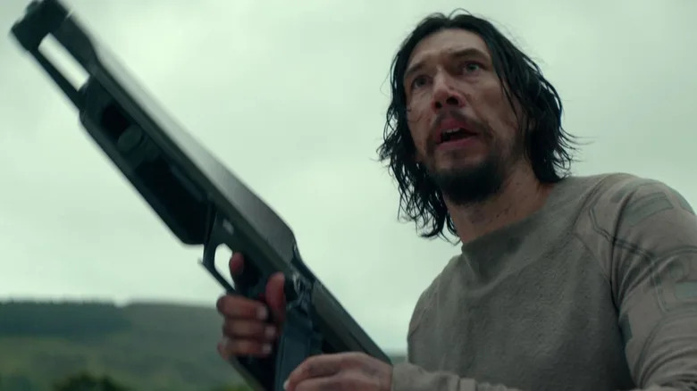 Adam Driver's Mills holds up a rifle in 65.jpg