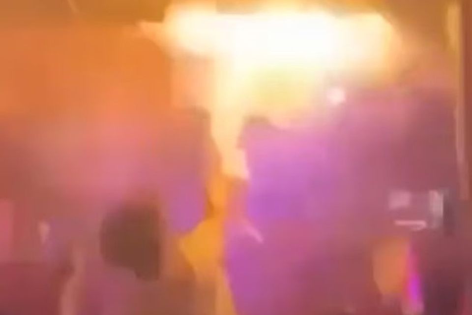 A man attempts to tackle the fire, moments before it spread. Video grab