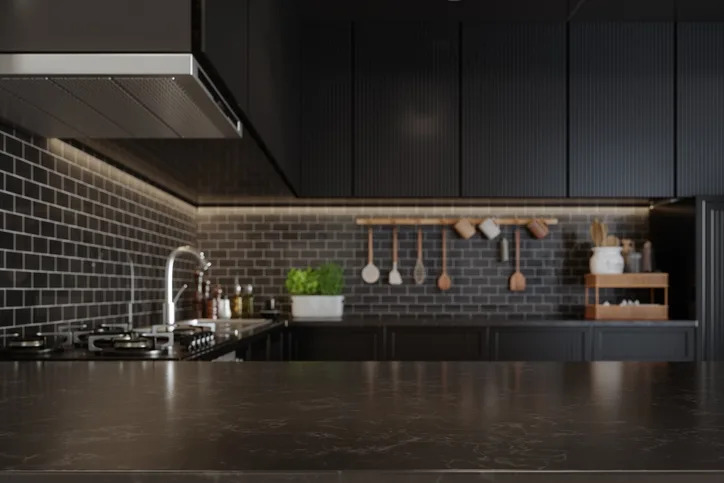 Modern kitchen with dark cabinets, tiled backsplash, stainless steel appliances, a potted plant, and utensils hanging on the wall
