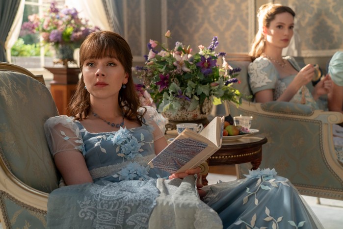 Claudia Jessie as Eloise Bridgerton sat reading a book in Bridgerton season 3.