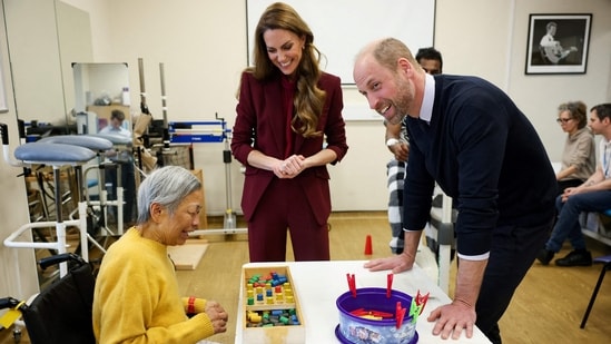 Britain's Prince William (R), Prince of Wales and Catherine (C), Princess of Wales speak to a patient at the therapy gym during a visit to Charing Cross Hospital in west London on January 8, 2026, to highlight the work of NHS staff and volunteers. (Photo by Isabel Infantes / POOL / AFP)(AFP)