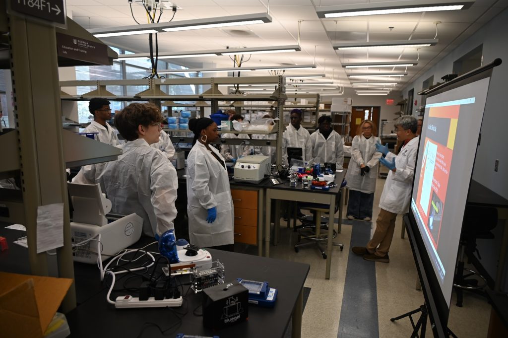 In this photo, you see students standing in a research laboratory inside the Georgia Cancer Center M. Bert Storey Research Building.