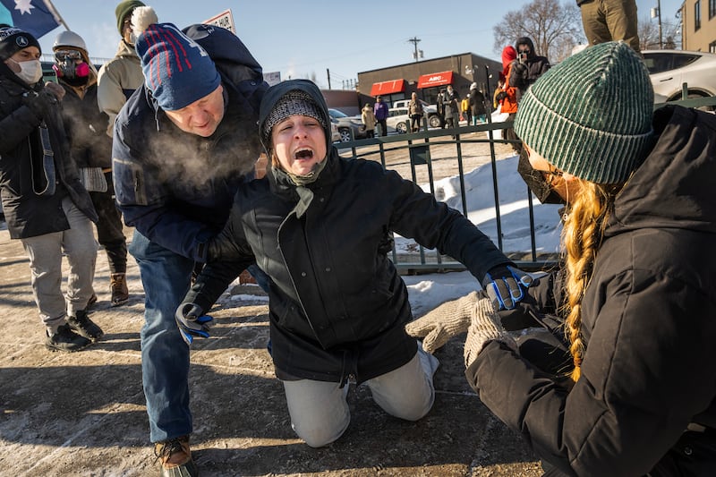A woman reacts after her partner was arrested and taken away as federal agents confront protestors in Minneapolis, on Saturday, Jan. 24, 2026. (Photo by David Guttenfelder/The New York Times)