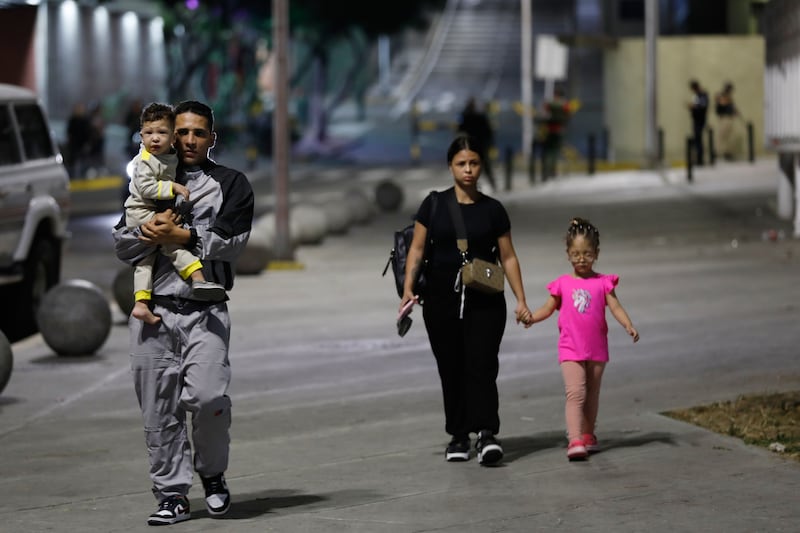 Pedestrians walk past the Miraflores presidential palace after explosions and low-flying aircraft were heard in Caracas. Photograph: Cristian Hernandez/AP