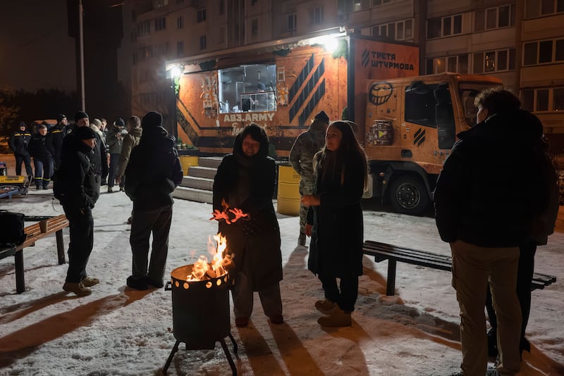 Residents gather around a fire at a mobile kitchen in Kyiv which provides food and warmth to those left without power or heat following Russian strikes on the city's critical infrastructure. Photograph: EPA